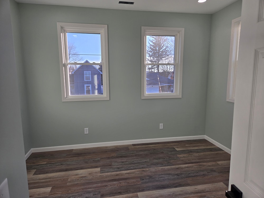 2 story home addition — completed second bedroom with sage green walls and two windows — Findlay, Ohio