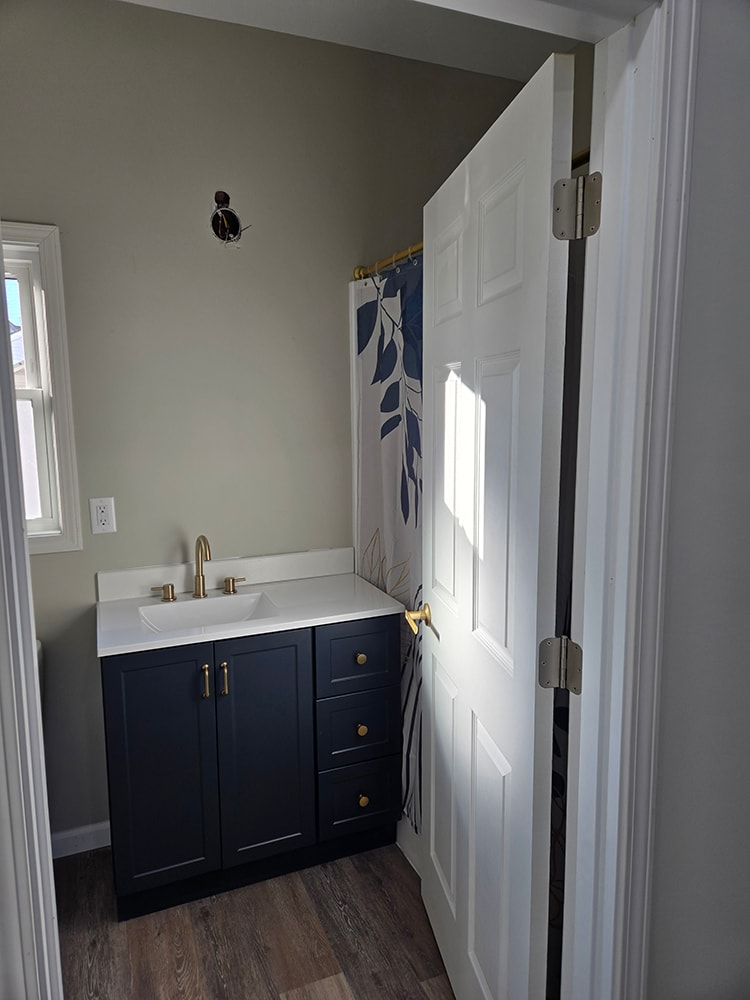 2 story home addition — completed upstairs bathroom with navy vanity and gold fixtures — Findlay, Ohio