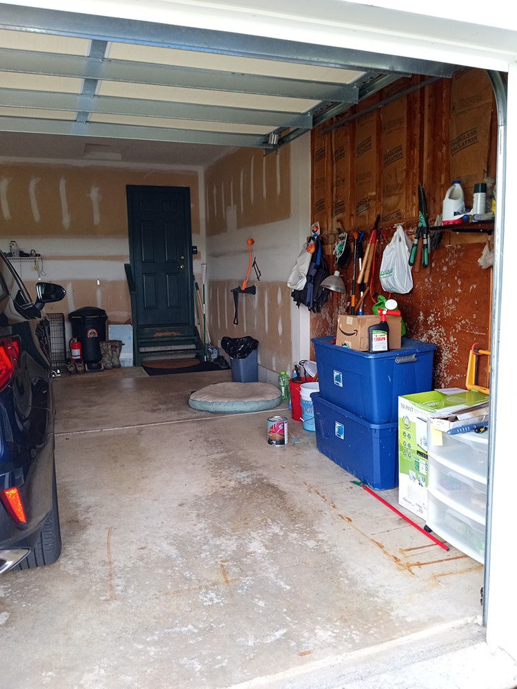 Siding, bathroom, garage & 1/2 bath — before: original garage interior with unfinished walls and storage — Attica, Ohio