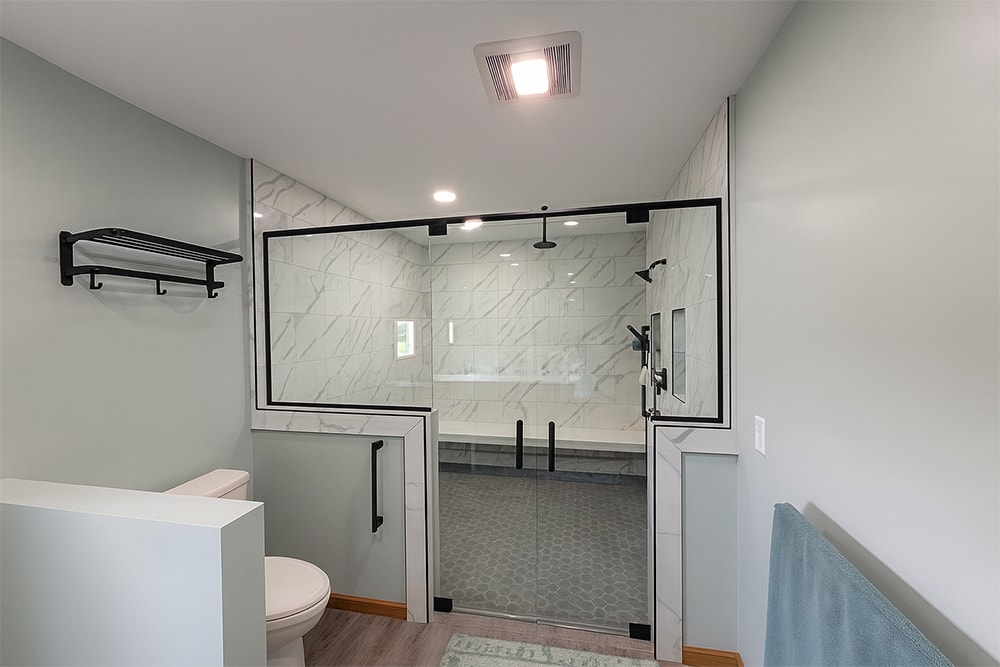 Siding, bathroom, garage & 1/2 bath — after: completed master bath walk-in shower with marble tile and black framed glass doors — Attica, Ohio