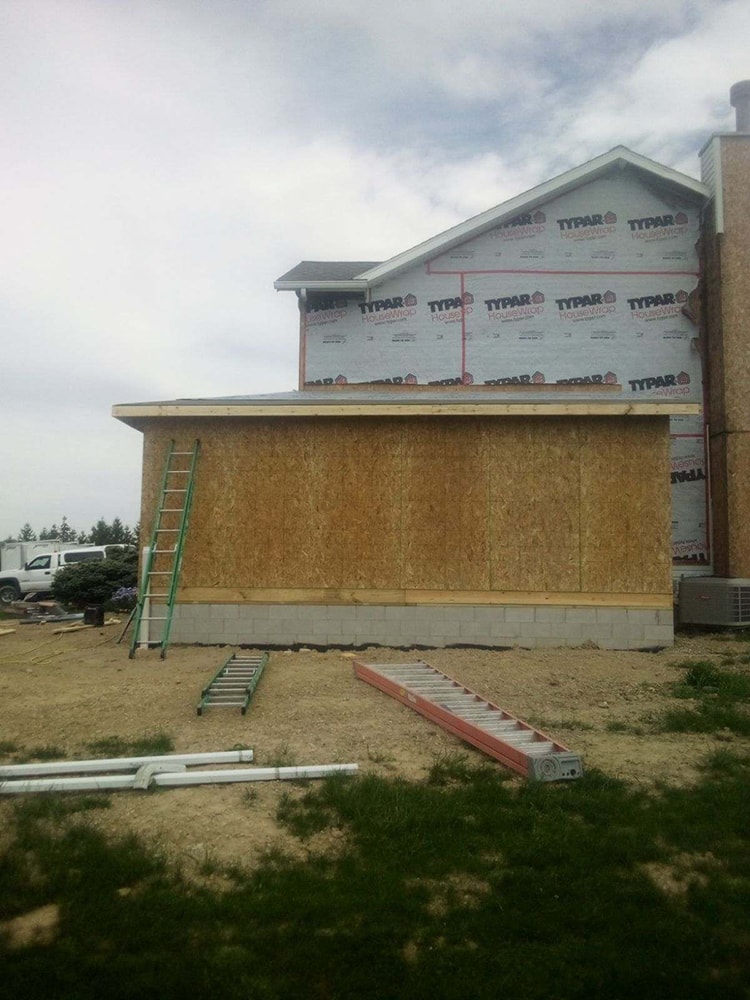 Siding, bathroom, garage & 1/2 bath — during: addition framing with housewrap on side elevation — Attica, Ohio