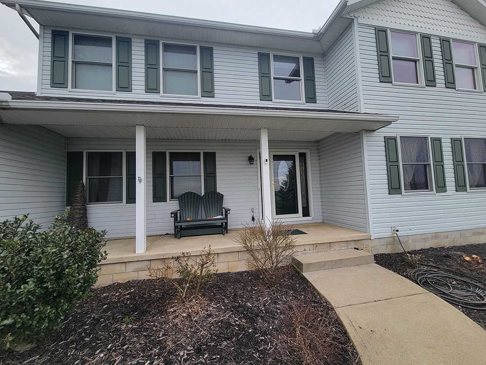Siding, bathroom, garage & 1/2 bath — after: completed front porch with new siding and covered entry — Attica, Ohio