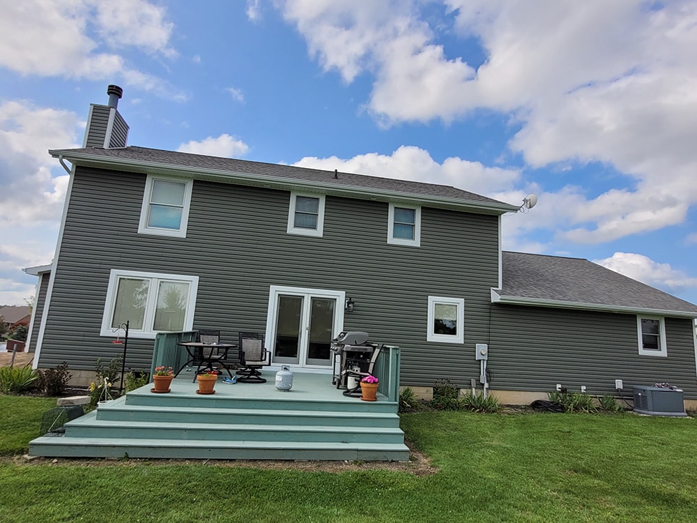 Siding, bathroom, garage & 1/2 bath — after: completed rear exterior with new gray siding and refreshed deck — Attica, Ohio