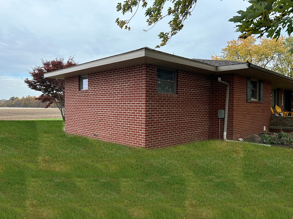 Bathroom/closet addition — after: completed brick addition corner view with matching brick and new windows — Findlay, Ohio