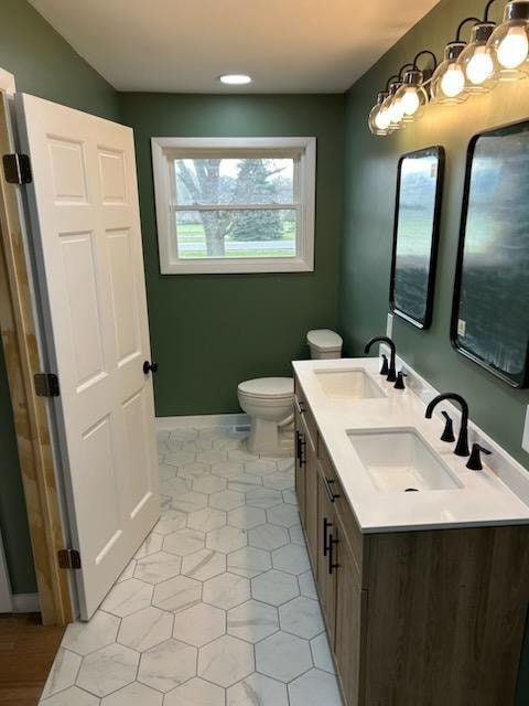 Bathroom/closet addition — after: master bathroom full view with double vanity, hexagonal tile floor, toilet, and green walls — Findlay, Ohio