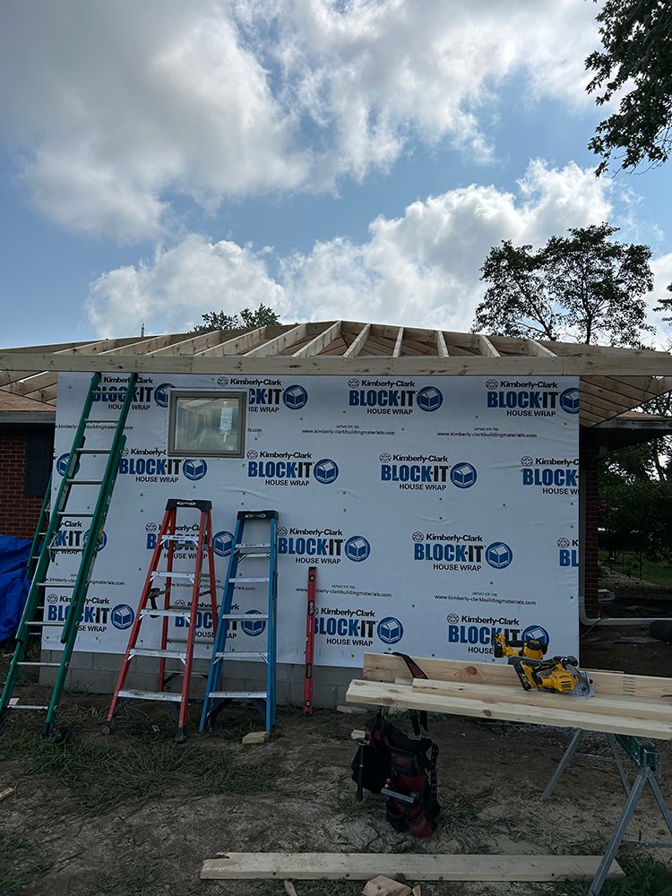 Bathroom/closet addition — during construction: framing with house wrap, roof trusses, and ladders — Findlay, Ohio