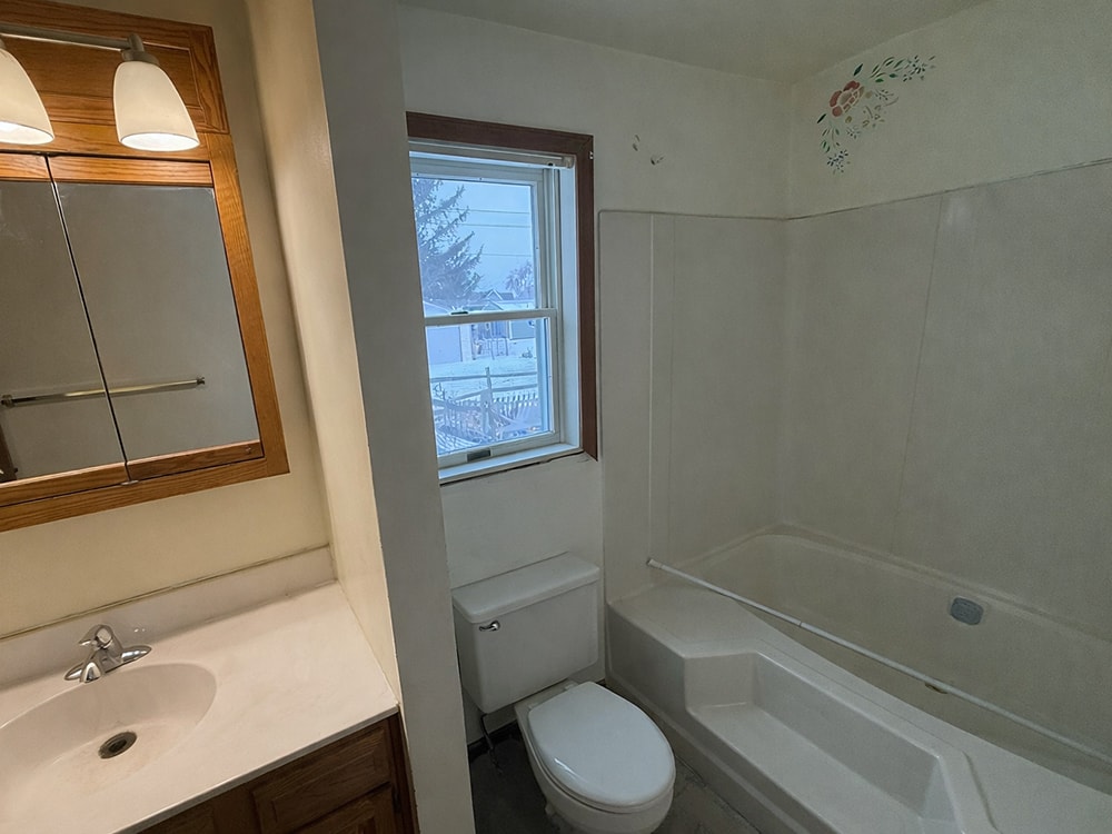 Before: full bathroom view with carpet and dated fixtures — Findlay, Ohio