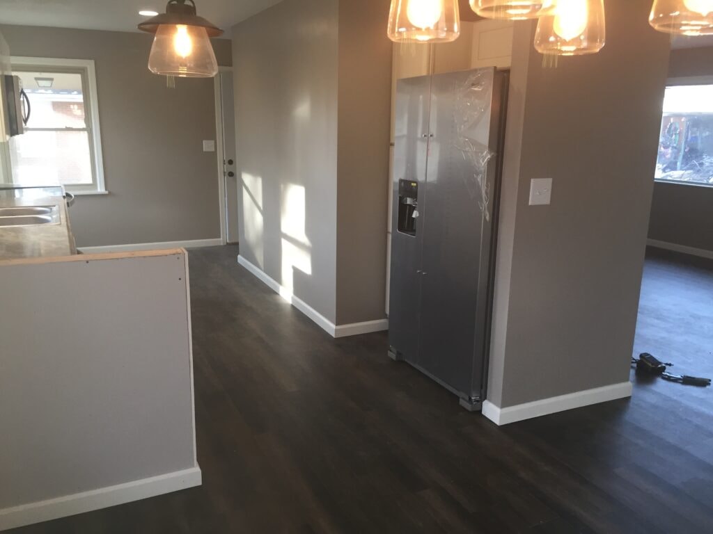 Complete home remodel Findlay — after: open concept kitchen and dining area with pendant lights and new LVP flooring, Findlay, Ohio