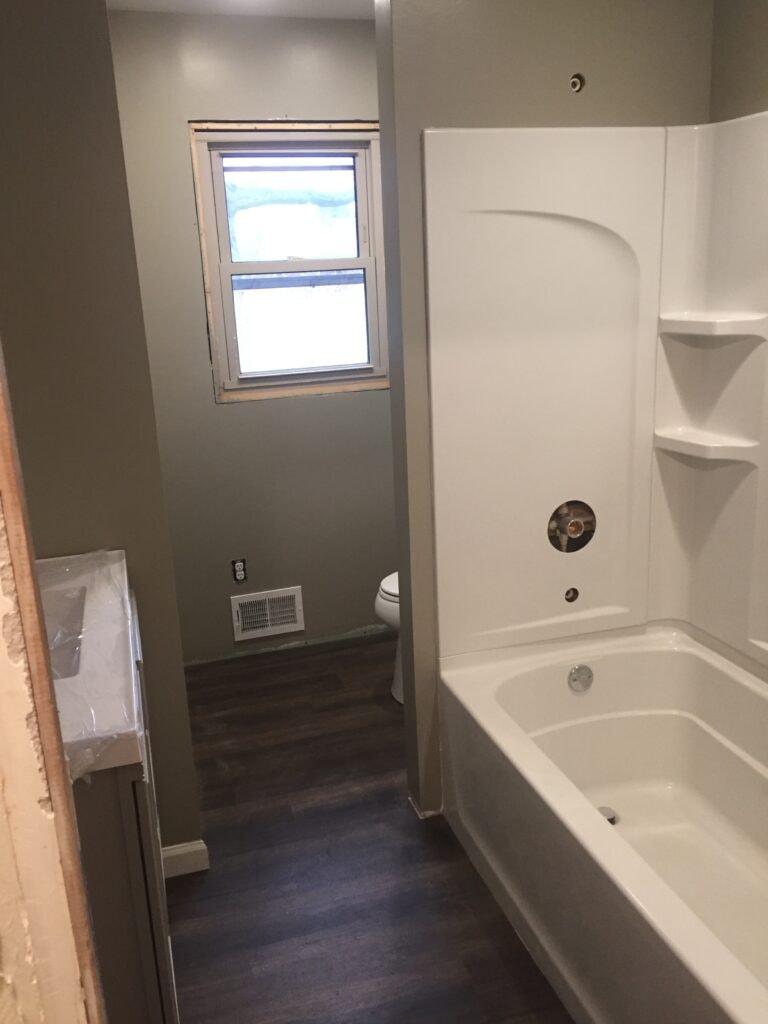 Complete home remodel Findlay — after: remodeled bathroom with new tub surround, LVP flooring and vanity, Findlay, Ohio