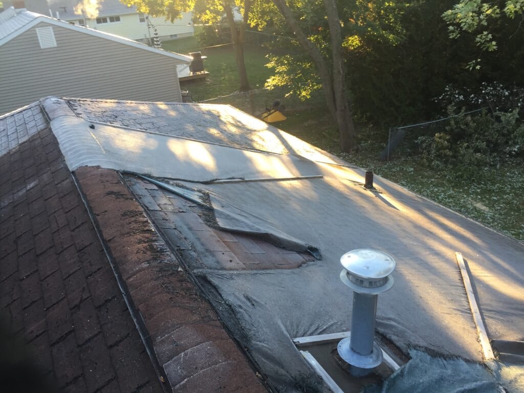 Complete home remodel Findlay — before: failing flat roof membrane with exposed decking, Findlay, Ohio