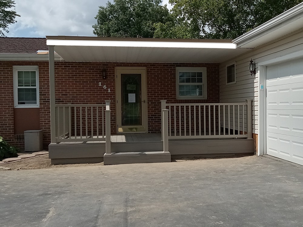Composite deck with flat roof — after: completed composite deck with flat roof, tan railing, and center stairs — Findlay, Ohio