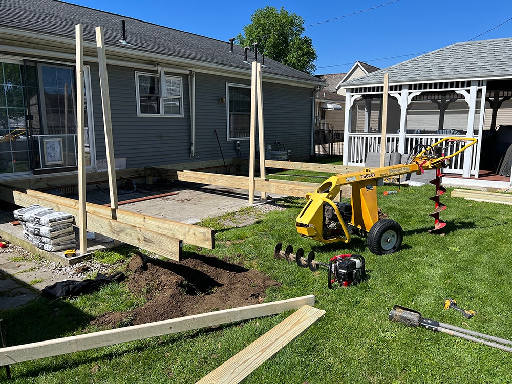 Composite deck — during construction: post holes drilled with Ground Hog auger, framing and posts visible in backyard, Findlay, Ohio