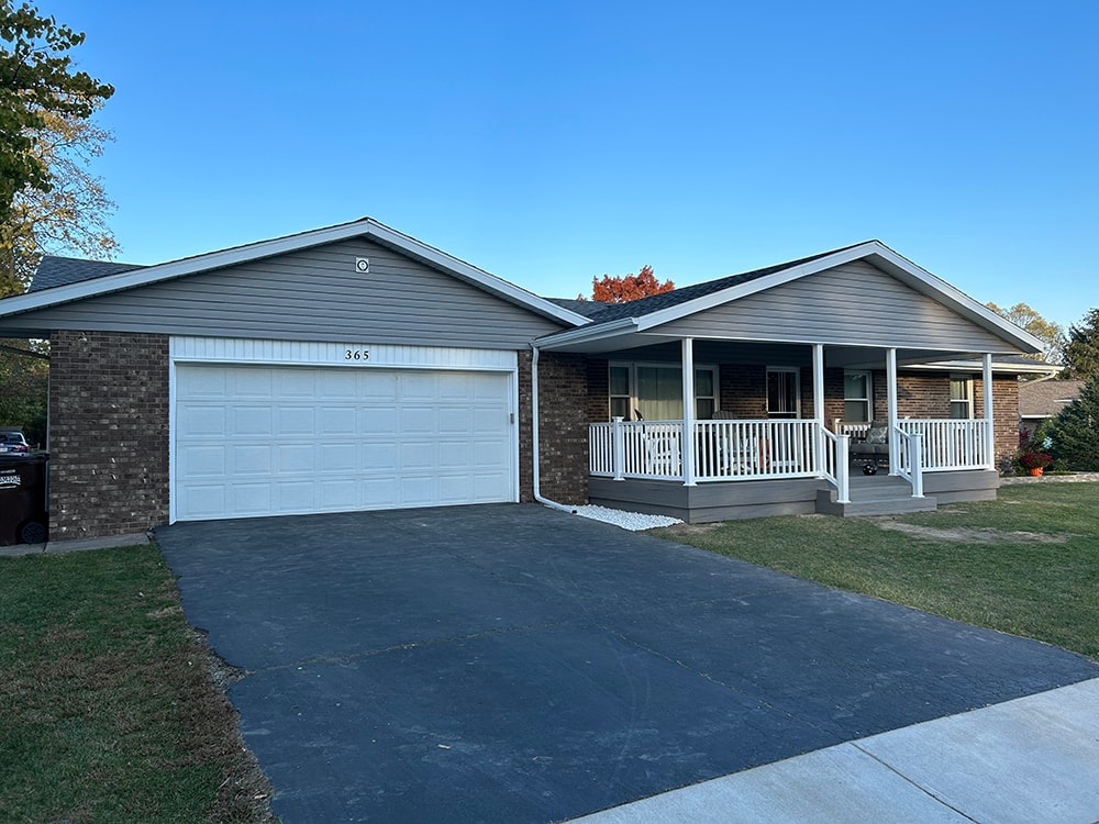 Composite deck with gable roof — after: completed front view from driveway with new gray siding and white railing — Bluffton, Ohio