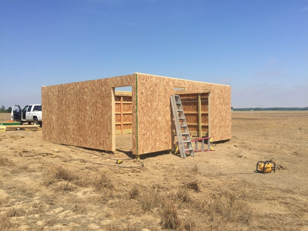 Garage build Arcadia — during: OSB sheathing installed on all walls with window and door openings cut, Arcadia, Ohio