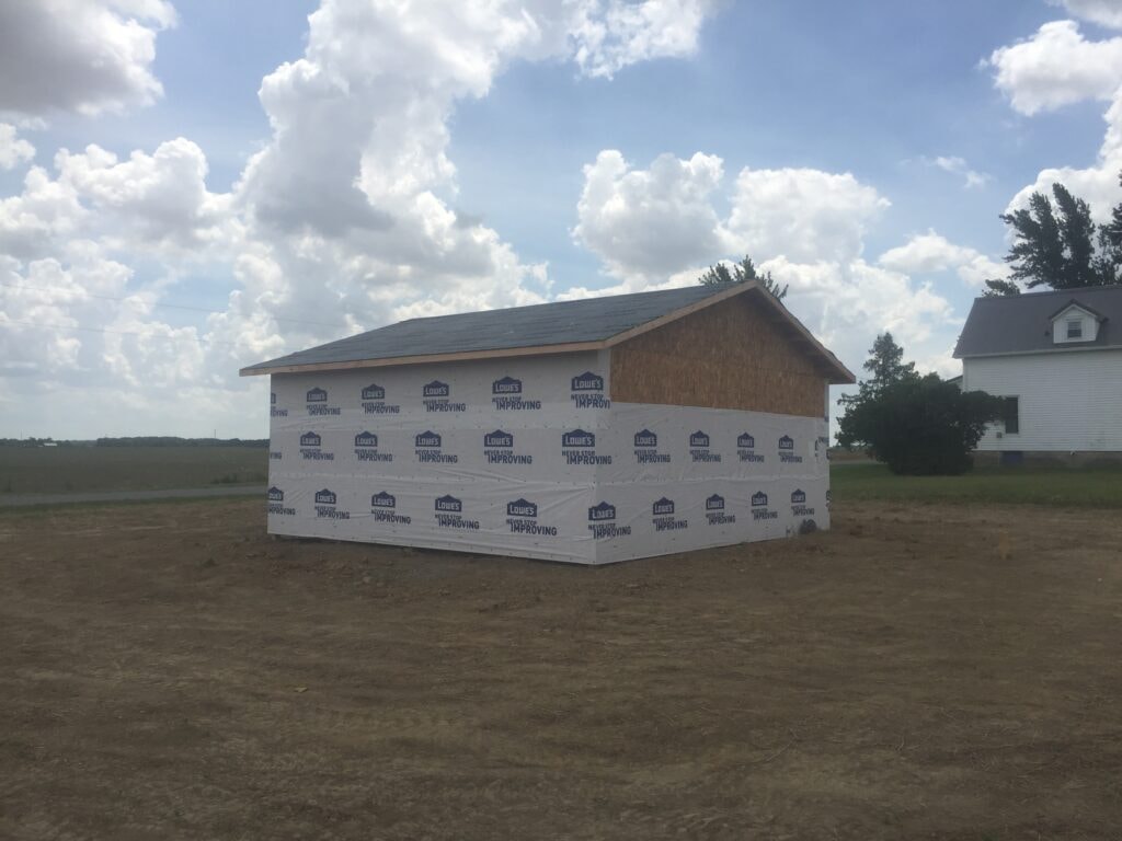 Garage build Arcadia — during: house wrap applied over sheathing with roof sheathed and drip edge installed, Arcadia, Ohio
