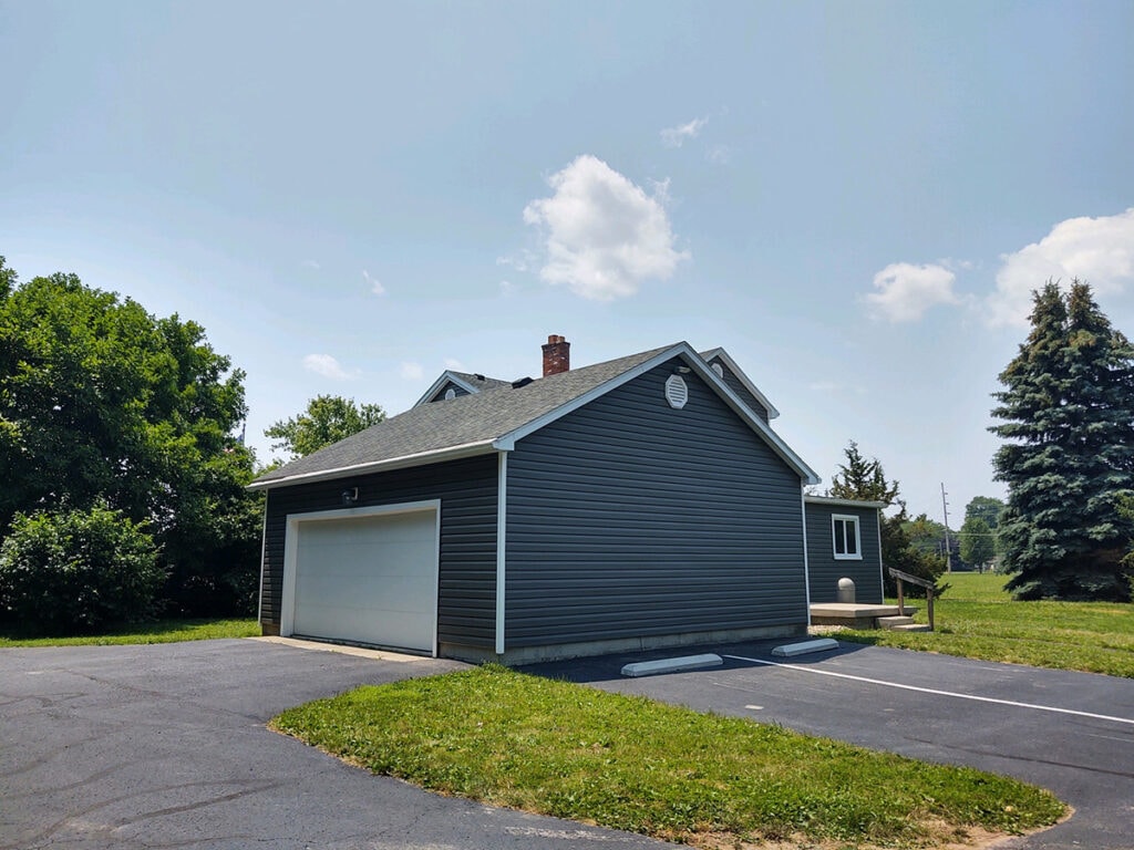 Hancock Park District siding — after: detached garage with new dark charcoal vinyl siding and white garage door, Findlay, Ohio