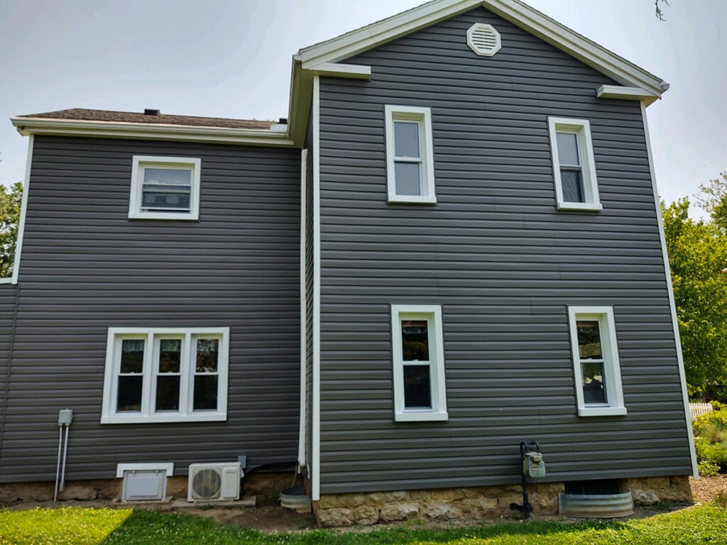 Hancock Park District siding — after: gable end of Welcome Center with new dark charcoal siding and white-wrapped windows, Findlay, Ohio