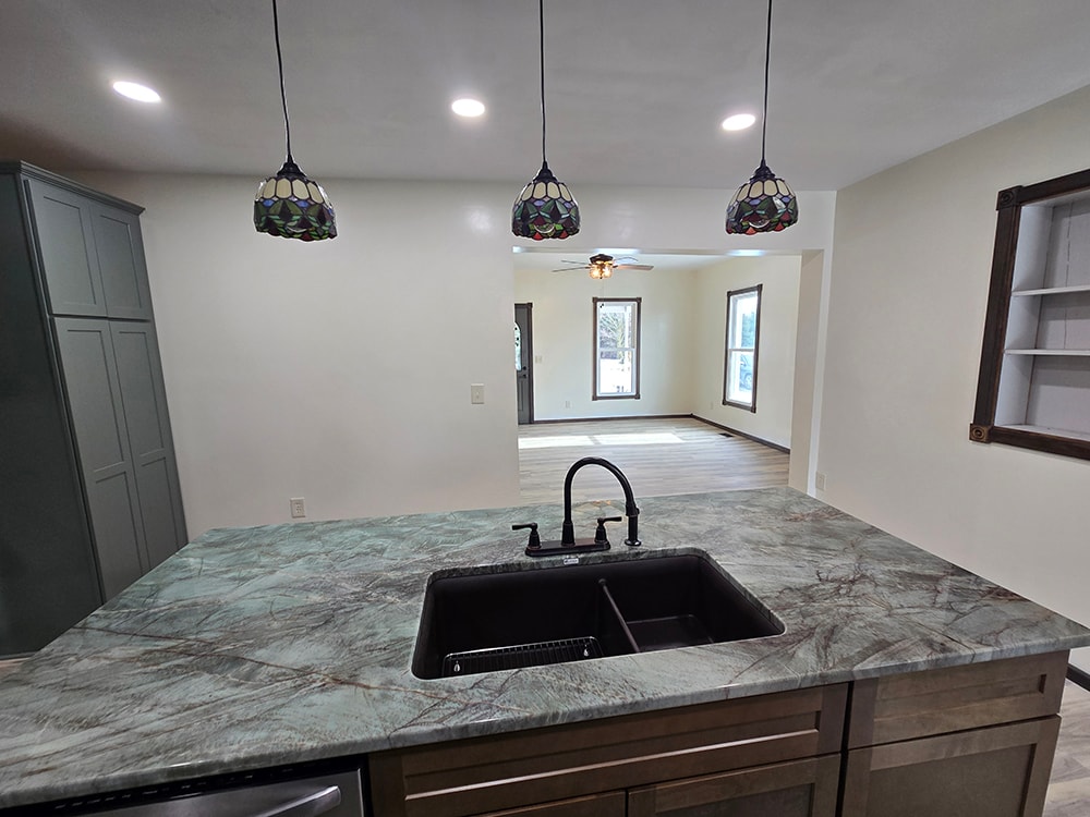 2 additions home remodel — after kitchen island with marble countertop and pendant lights — Findlay, Ohio