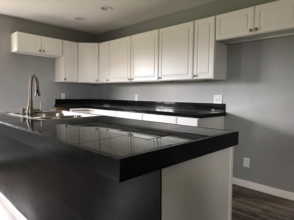 Finished kitchen with white cabinets and black tile countertop — Arcadia, Ohio