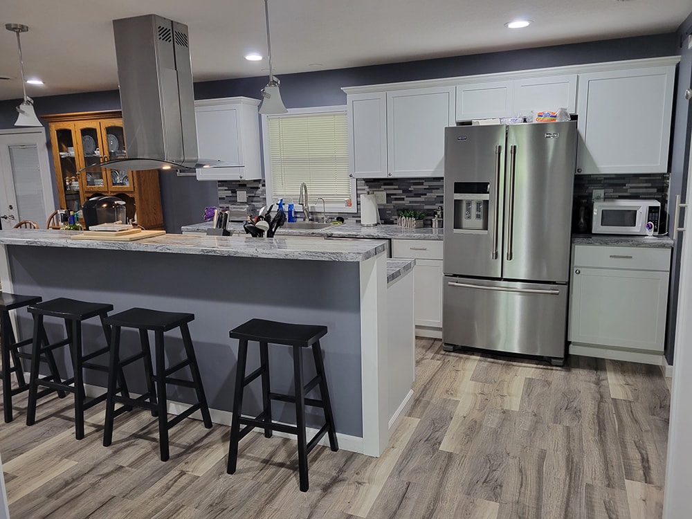 Kitchen remodel Findlay — after: island with bar seating and stainless refrigerator, Findlay, Ohio