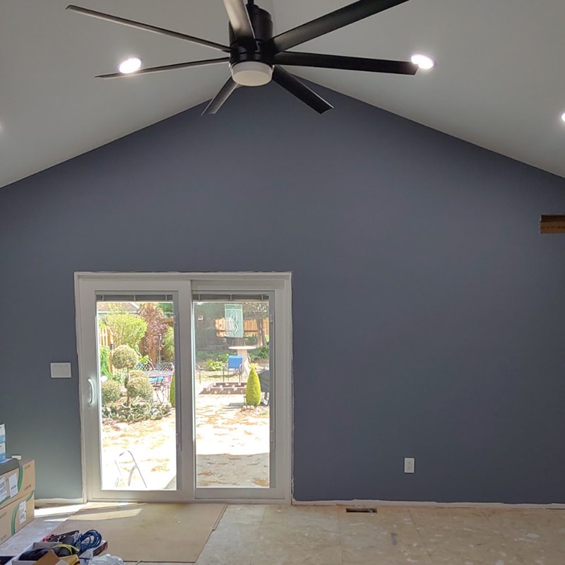 Large home addition — interior family room painted blue-gray with vaulted ceiling, recessed lights, ceiling fan, and patio door, Findlay, Ohio
