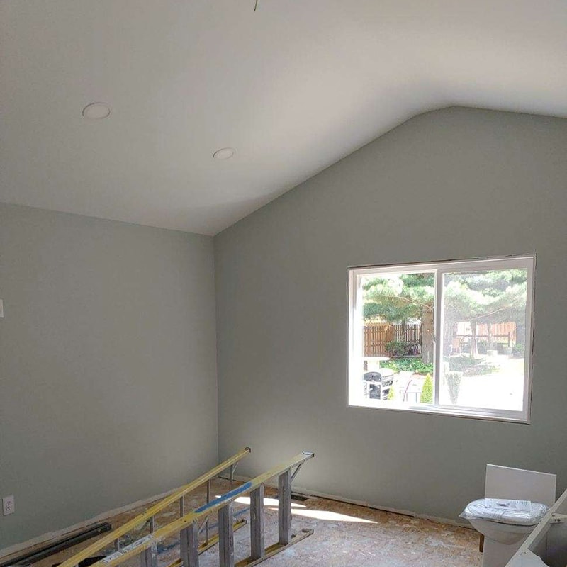 Large home addition — interior second room painted sage green with vaulted ceiling, recessed lights, and large window, Findlay, Ohio