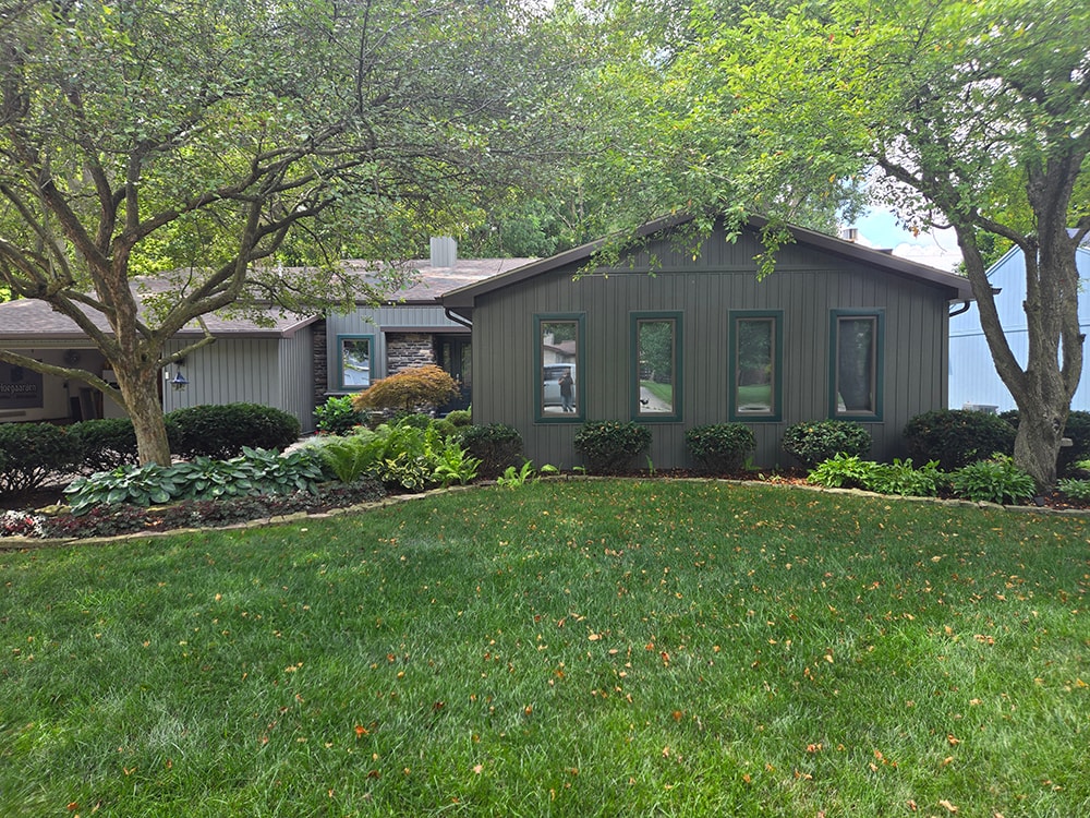 New board and batten siding — after: full front view with new siding and mature landscaping — Findlay, Ohio