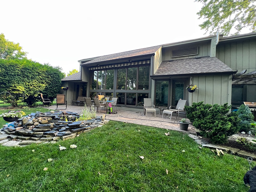 New board and batten siding — before: rear exterior with original siding and patio at dusk — Findlay, Ohio