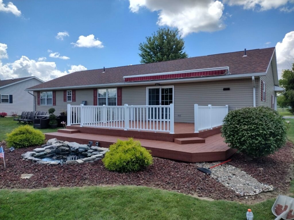 New composite deck — after, full backyard view showing completed composite deck with white railing and steps, Fostoria, Ohio
