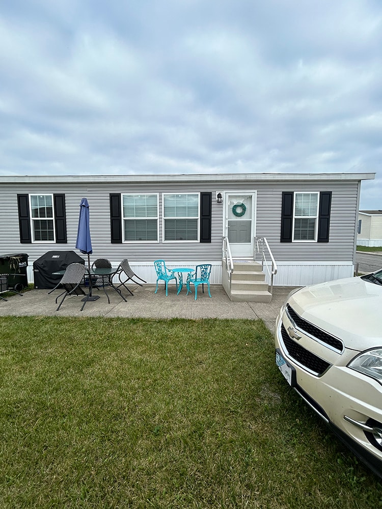 New composite deck with roof — before: mobile home full front view with original patio — Findlay, Ohio