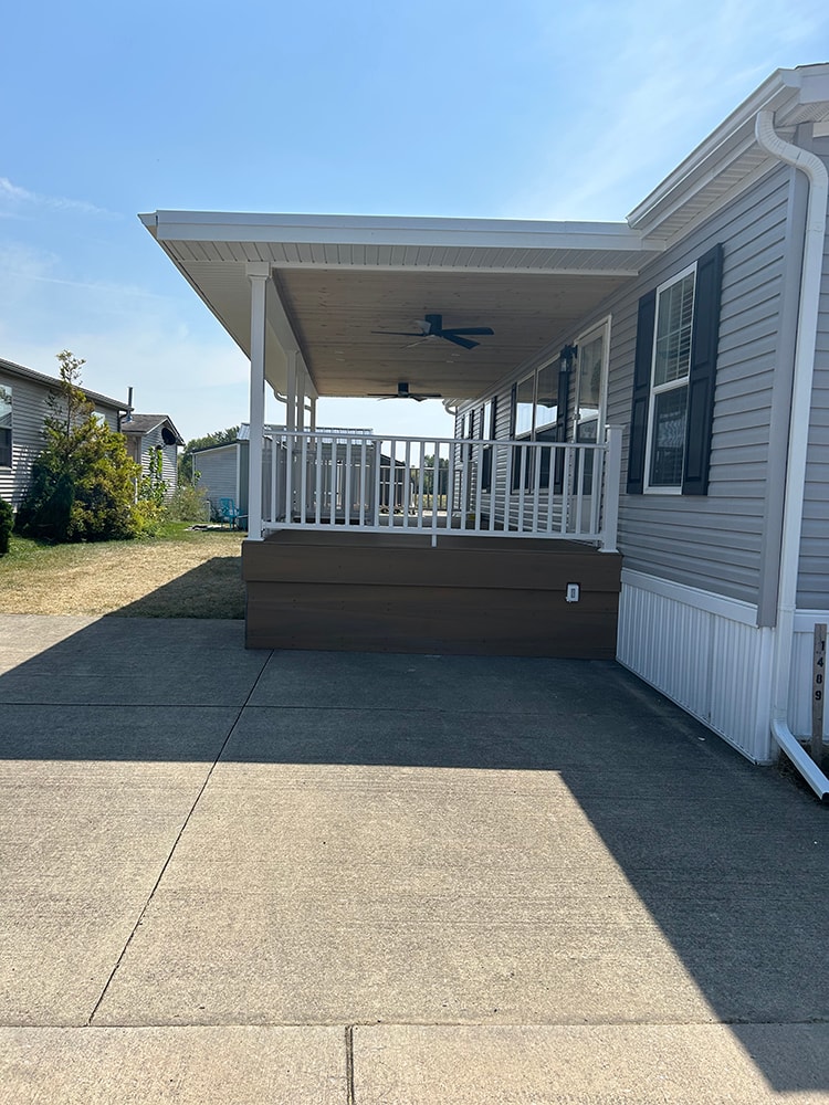 New composite deck with roof — completed side view with white railings and covered roof — Findlay, Ohio