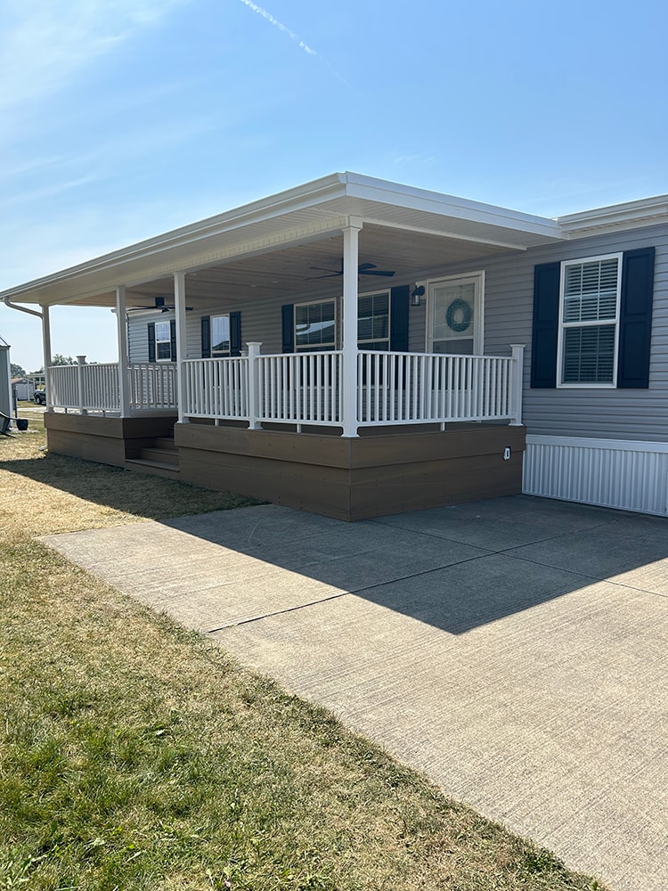 New composite deck with roof — completed front view with white railings and center stairs — Findlay, Ohio