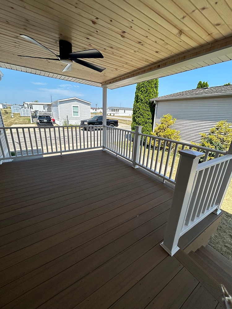 New composite deck with roof — deck surface view with ceiling fan and white railings — Findlay, Ohio