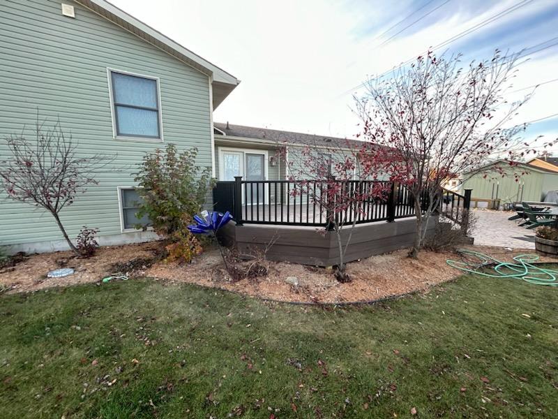 New composite deck — after: completed deck with black railing, side view from yard — Findlay, Ohio