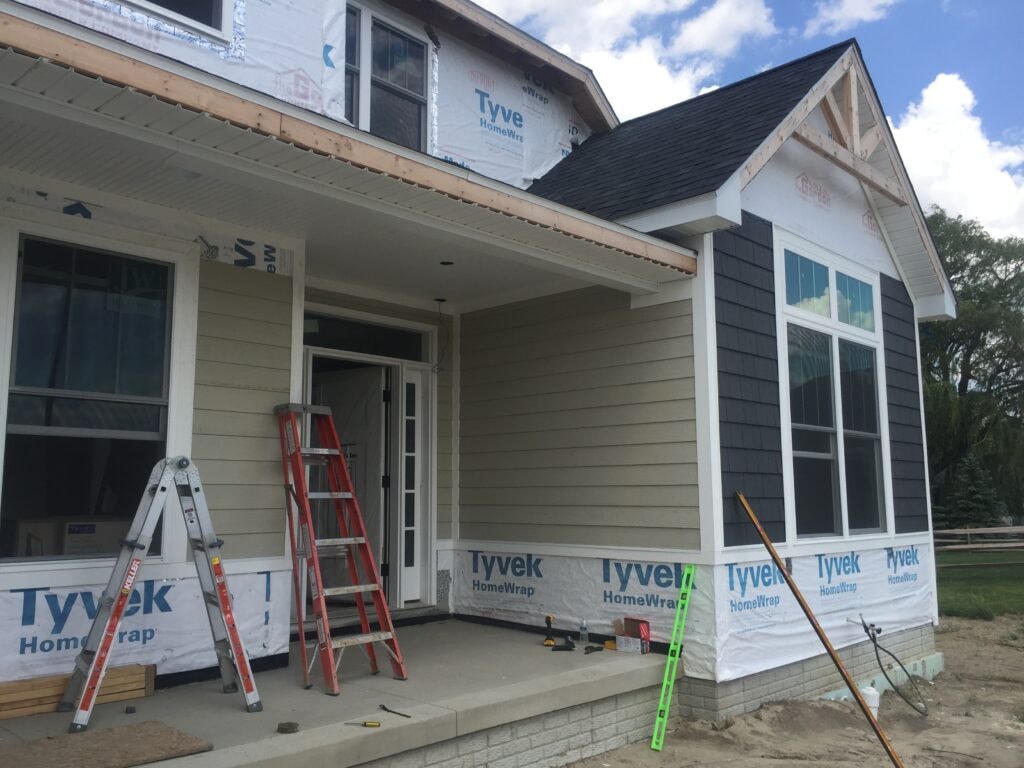 New construction composite siding Bowling Green — during: Tyvek wrap with siding partially installed on front porch, Bowling Green, Ohio