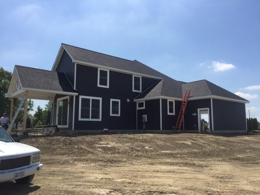 New construction composite siding Bowling Green — during: rear view with dark AZEK siding mostly complete, Bowling Green, Ohio