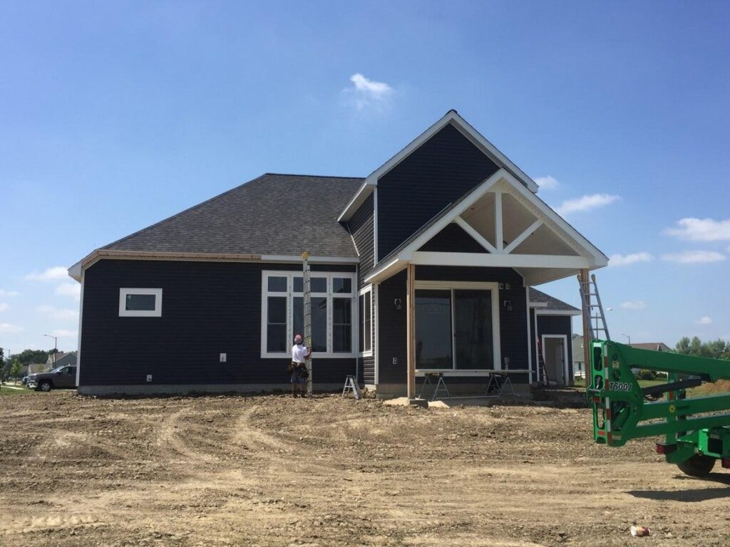 New construction composite siding Bowling Green — during: rear gable porch view with boom lift on site, Bowling Green, Ohio