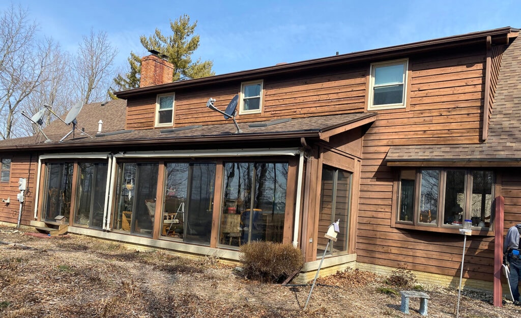New siding Findlay — before: rear of home with original brown cedar siding and large sunroom addition, Findlay, Ohio
