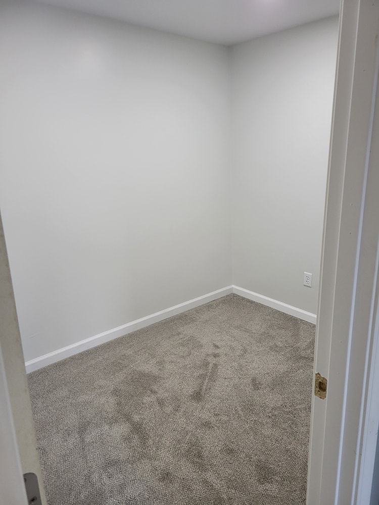 Rental home remodel after — small bedroom with white walls and new carpet, Findlay, Ohio