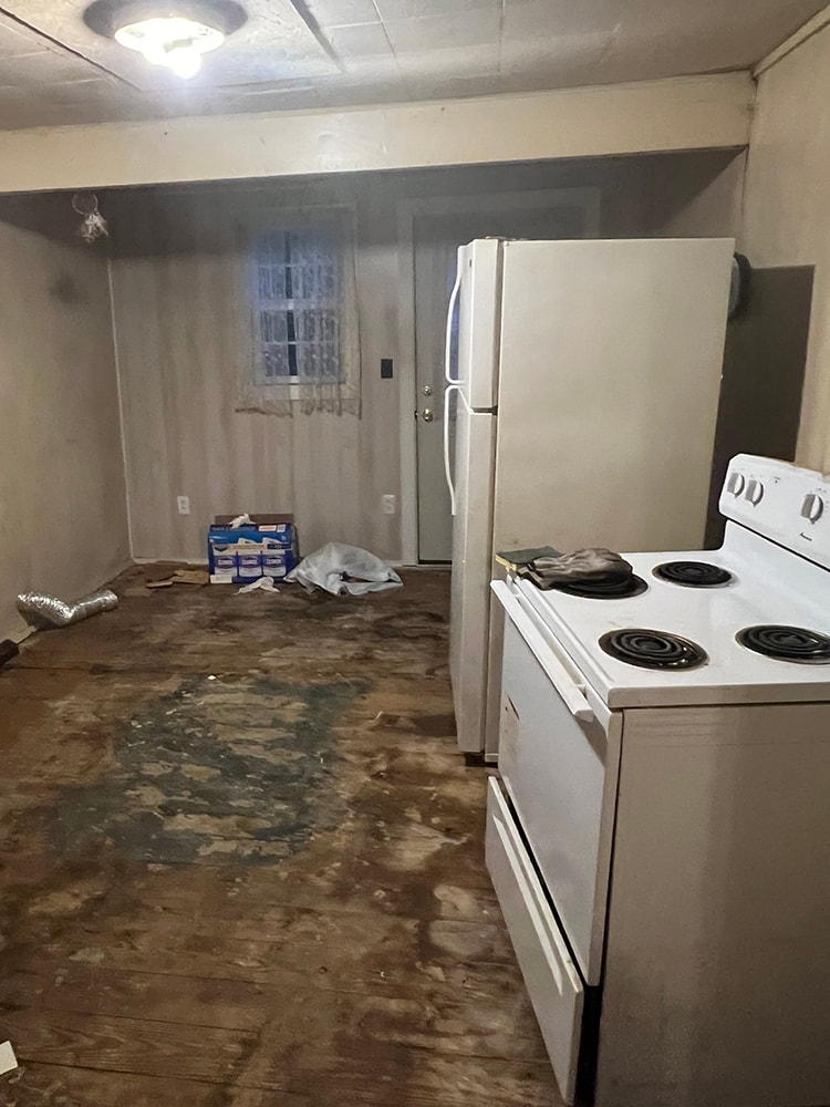 Rental home remodel before — kitchen with old appliances, stove, and damaged flooring, Findlay, Ohio