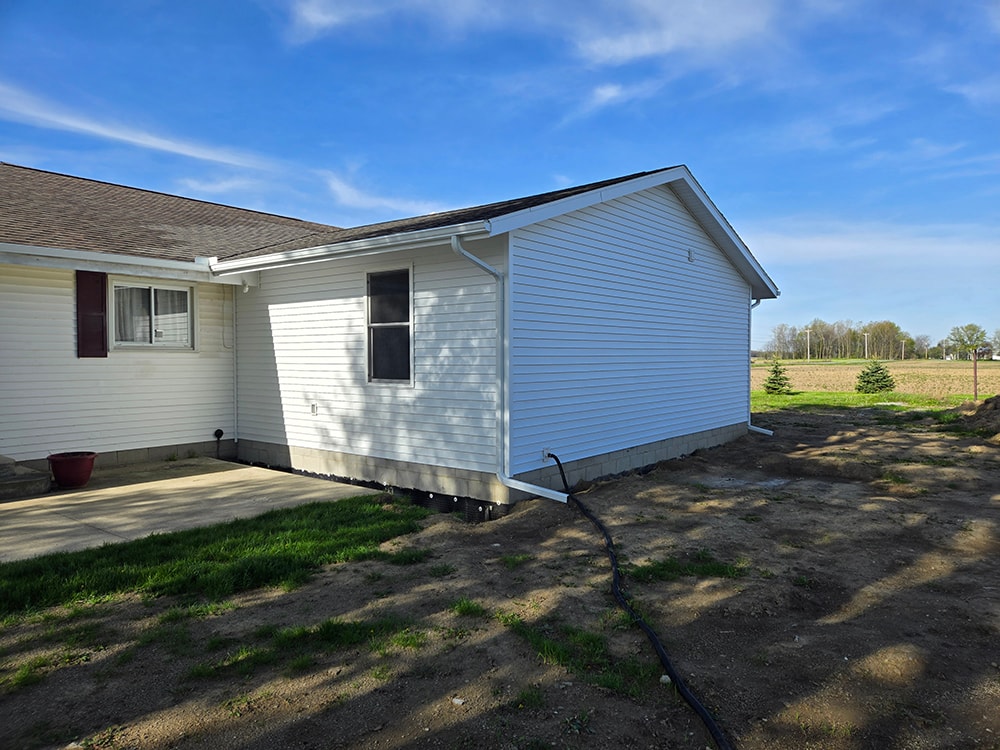 Home addition — completed exterior side view with new white siding and gutters — Findlay, Ohio