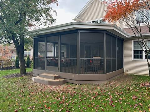 Screened-in composite deck — after: wider exterior view showing screened deck with flat roof attached to home — Findlay, Ohio