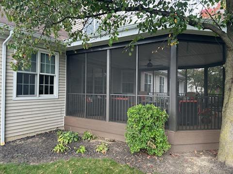 Screened-in composite deck — after: side exterior view of screened deck with flat roof and landscaping — Findlay, Ohio