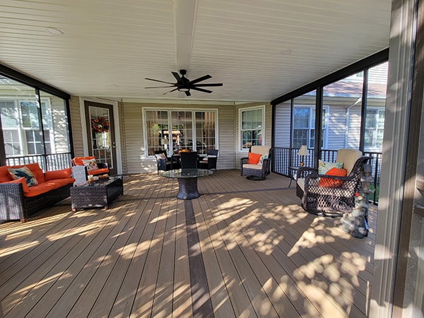 Screened-in composite deck — after: interior view from entry showing ceiling fan, composite floor, and screened walls — Findlay, Ohio