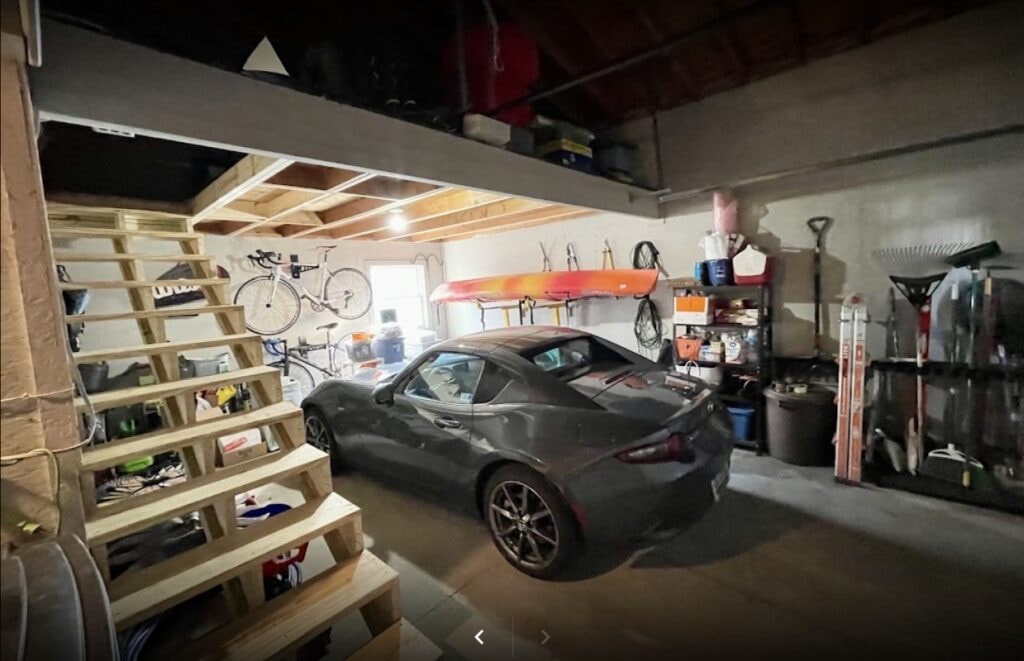Siding, deck, flooring and stairs — garage interior with custom built attic loft stairs and sports car, Findlay, Ohio