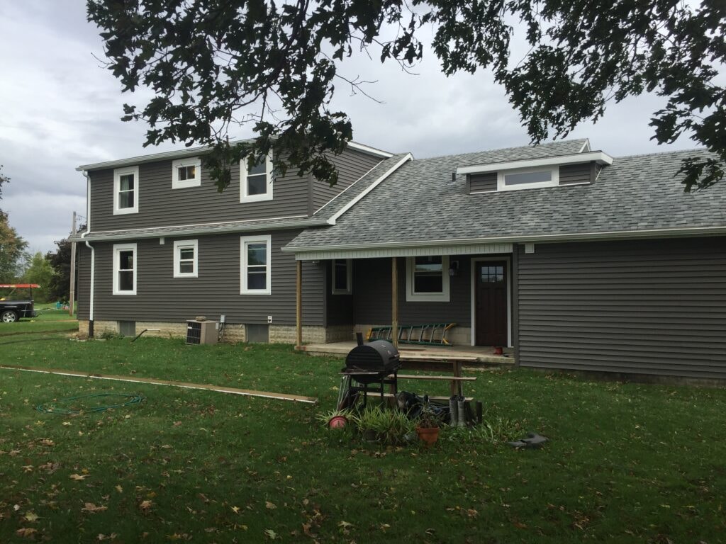 Siding and new windows Findlay — after: rear view of completed two-story home with new dark gray vinyl siding and white-trimmed windows, Findlay, Ohio
