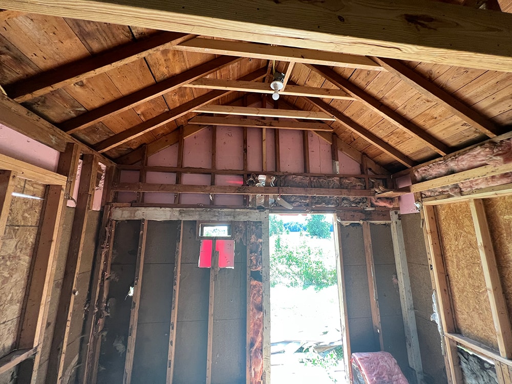 Small room reframe — interior demo, exposed roof framing and gutted walls with insulation removed, Findlay, Ohio