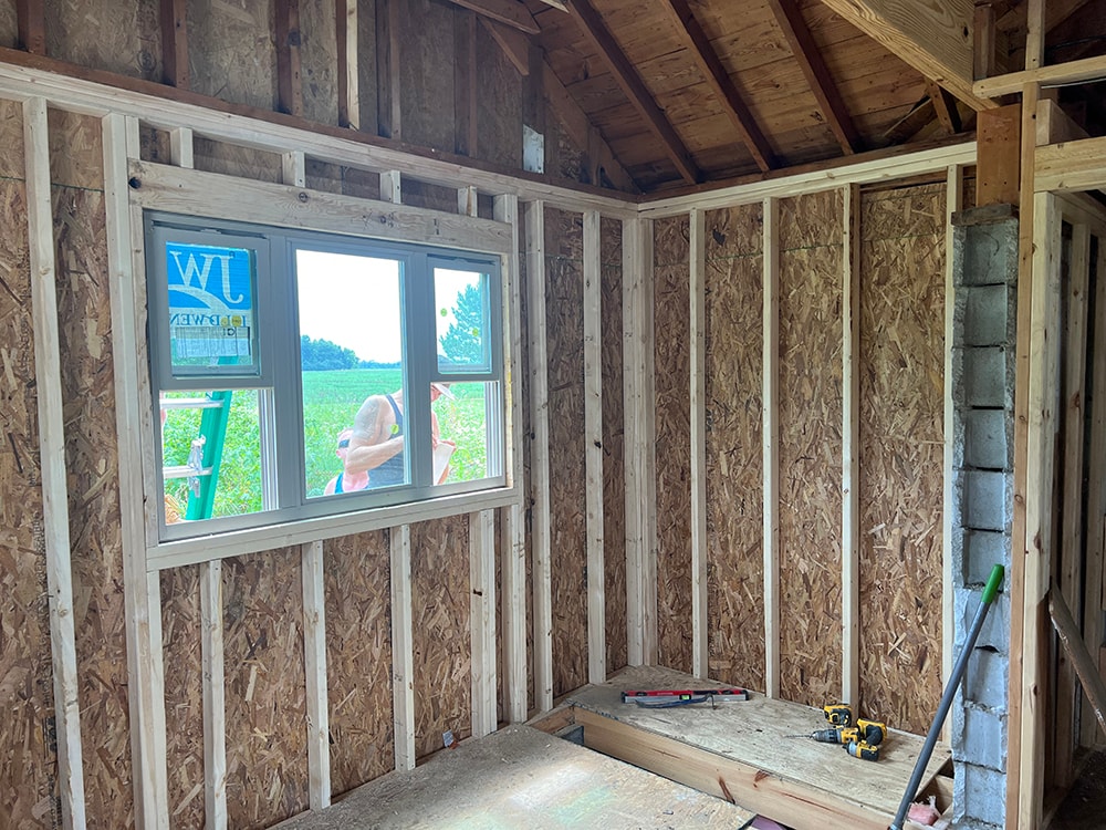 Small room reframe — new framing with OSB sheathing and new window installed, interior view showing completed wall framing, Findlay, Ohio