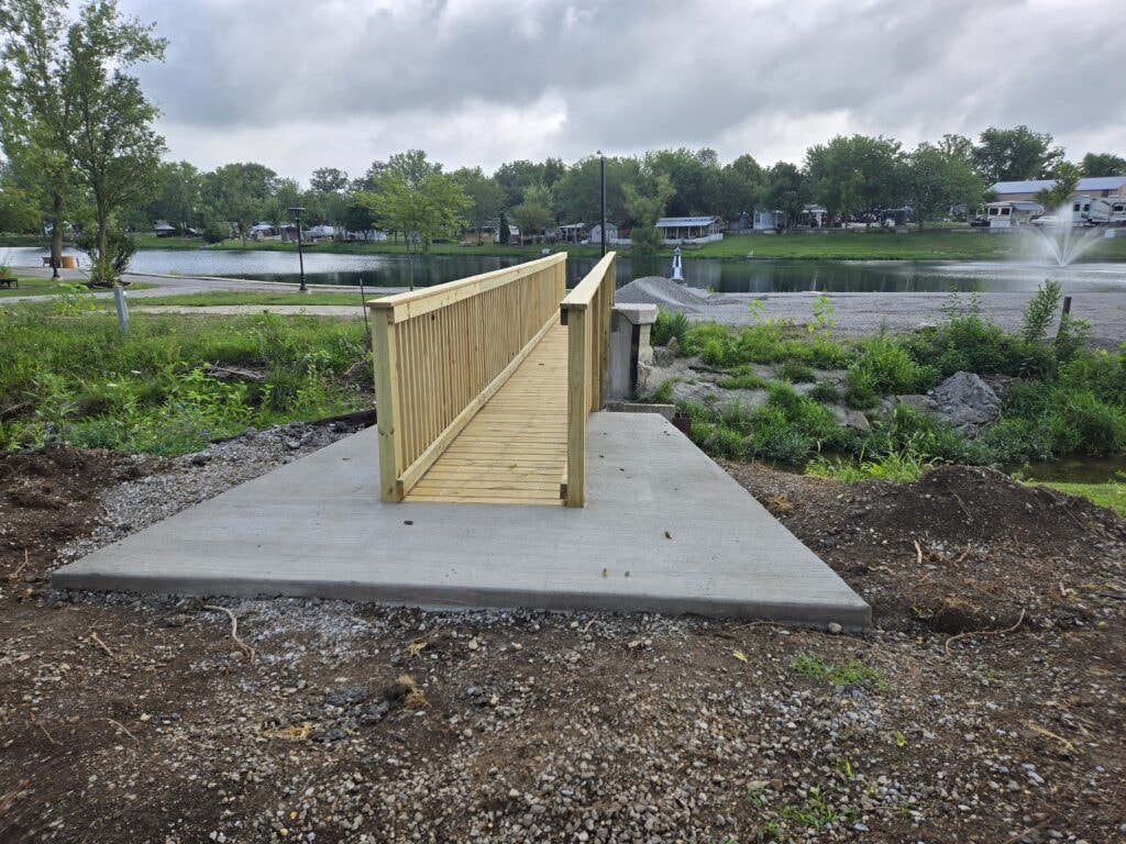 Steel and treated wood bridges — bridge 3 completed front view with wood railings and lake in background — Findlay, Ohio