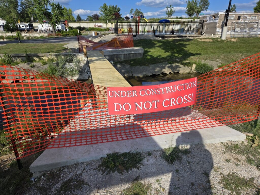 Steel and treated wood bridges — bridge 2 under construction with orange safety netting and do not cross sign — Findlay, Ohio